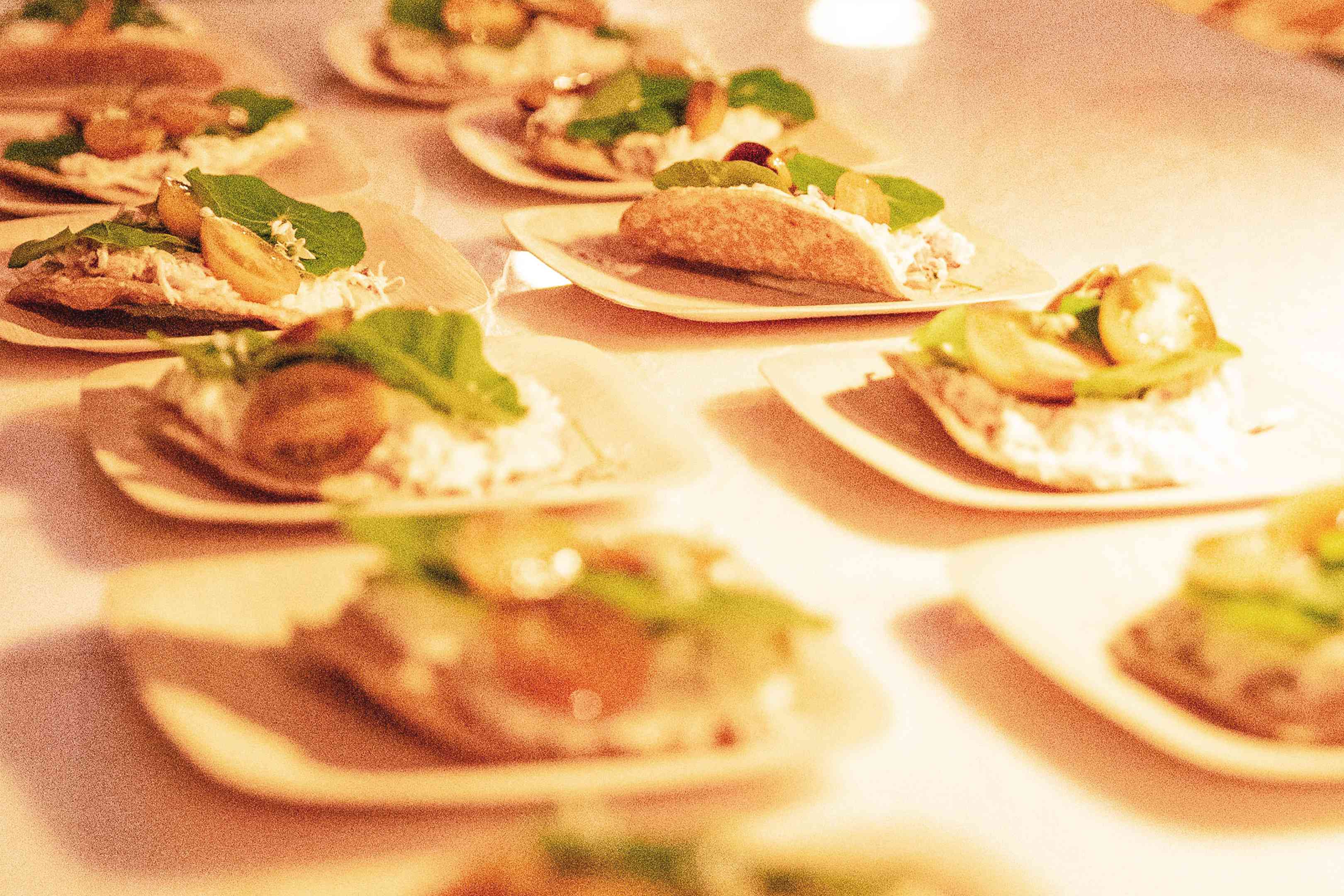 A table topped with lots of small plates of food.
