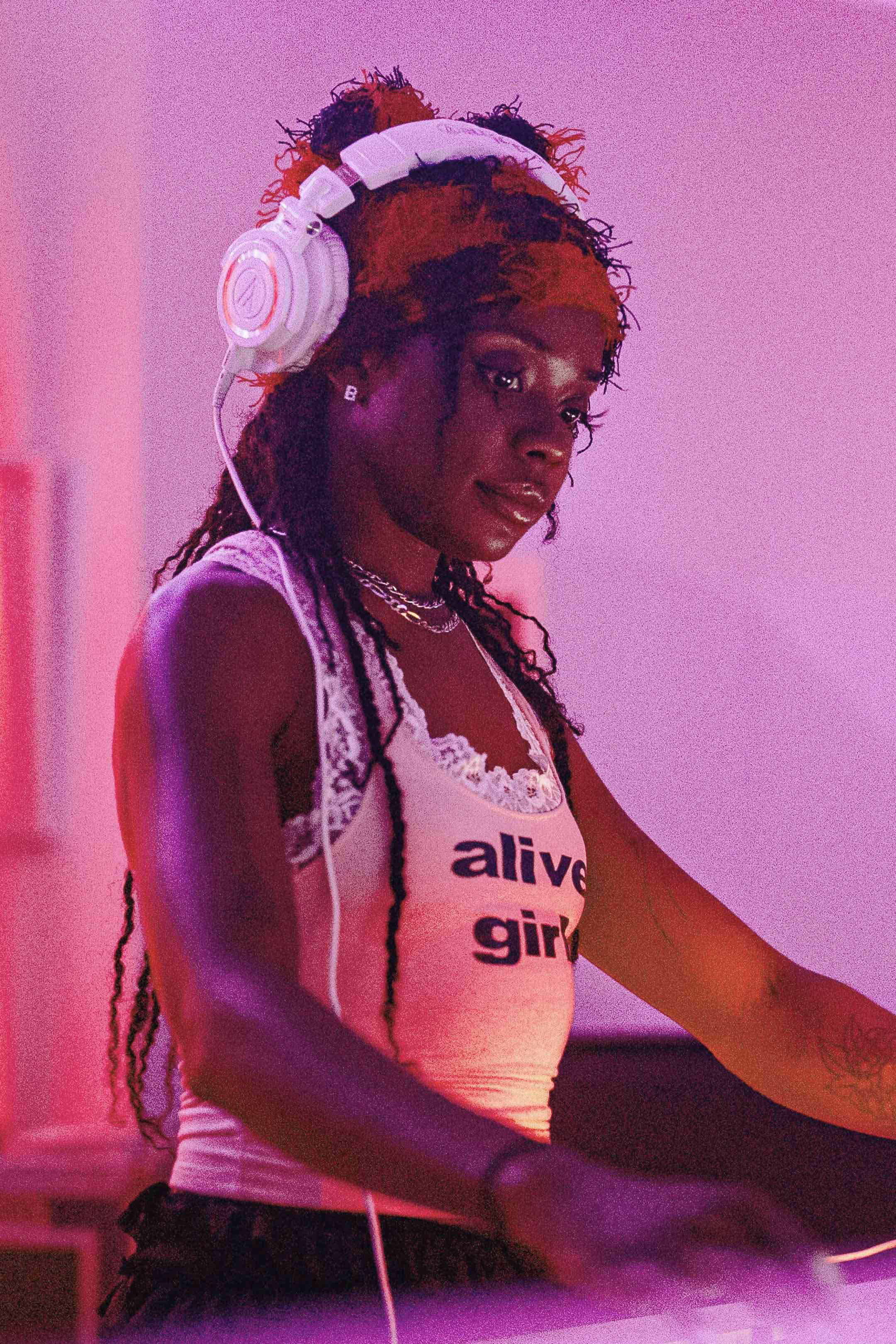 A woman with headphones on playing a dj set.