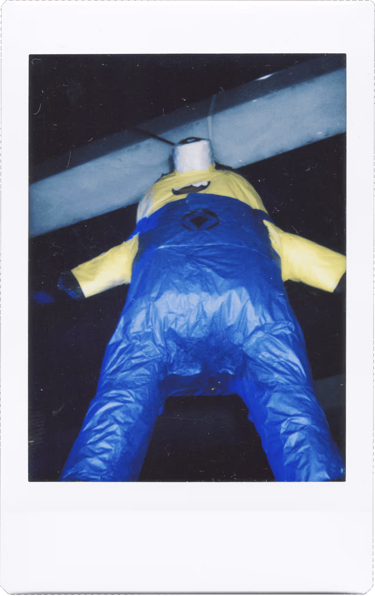 A blue and yellow inflatable man is in the air.
