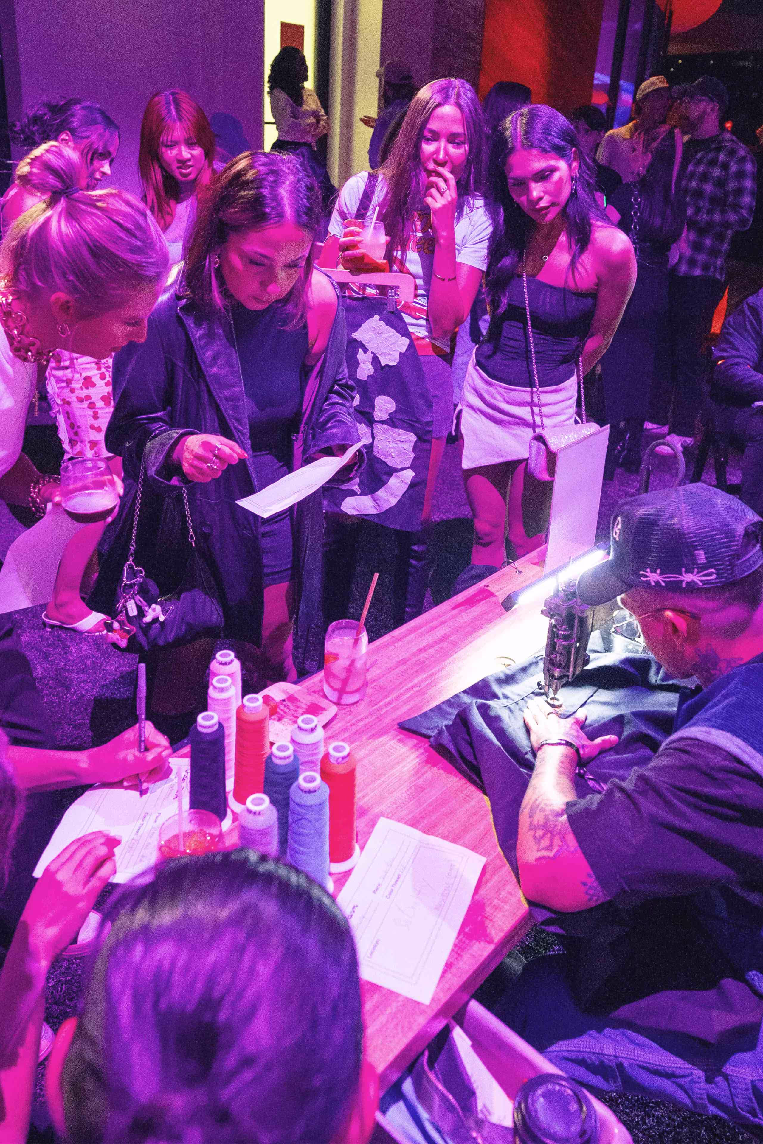people are gathered around a table with a knife and a bottle of wine