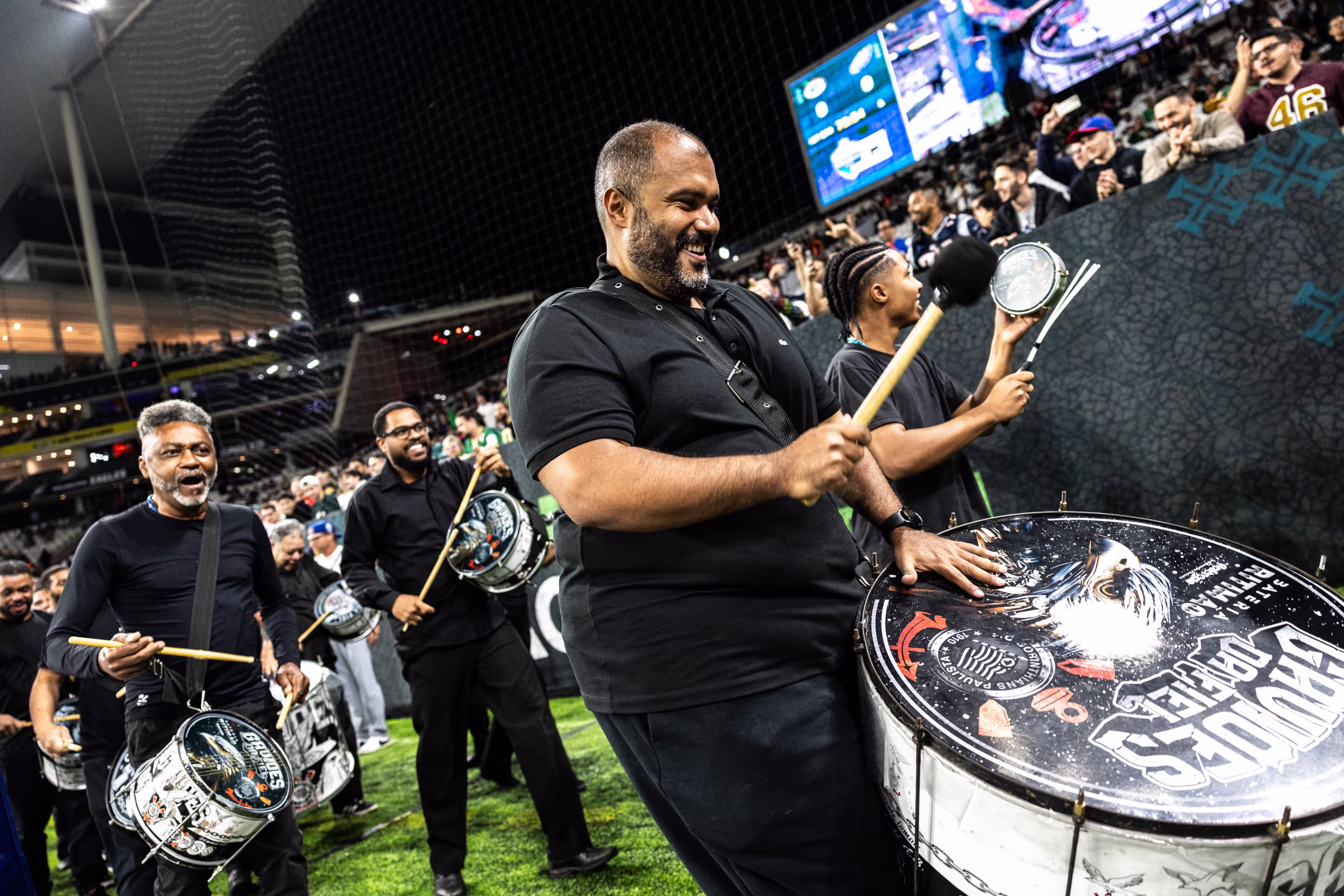 A man holding a drum on a soccer field.