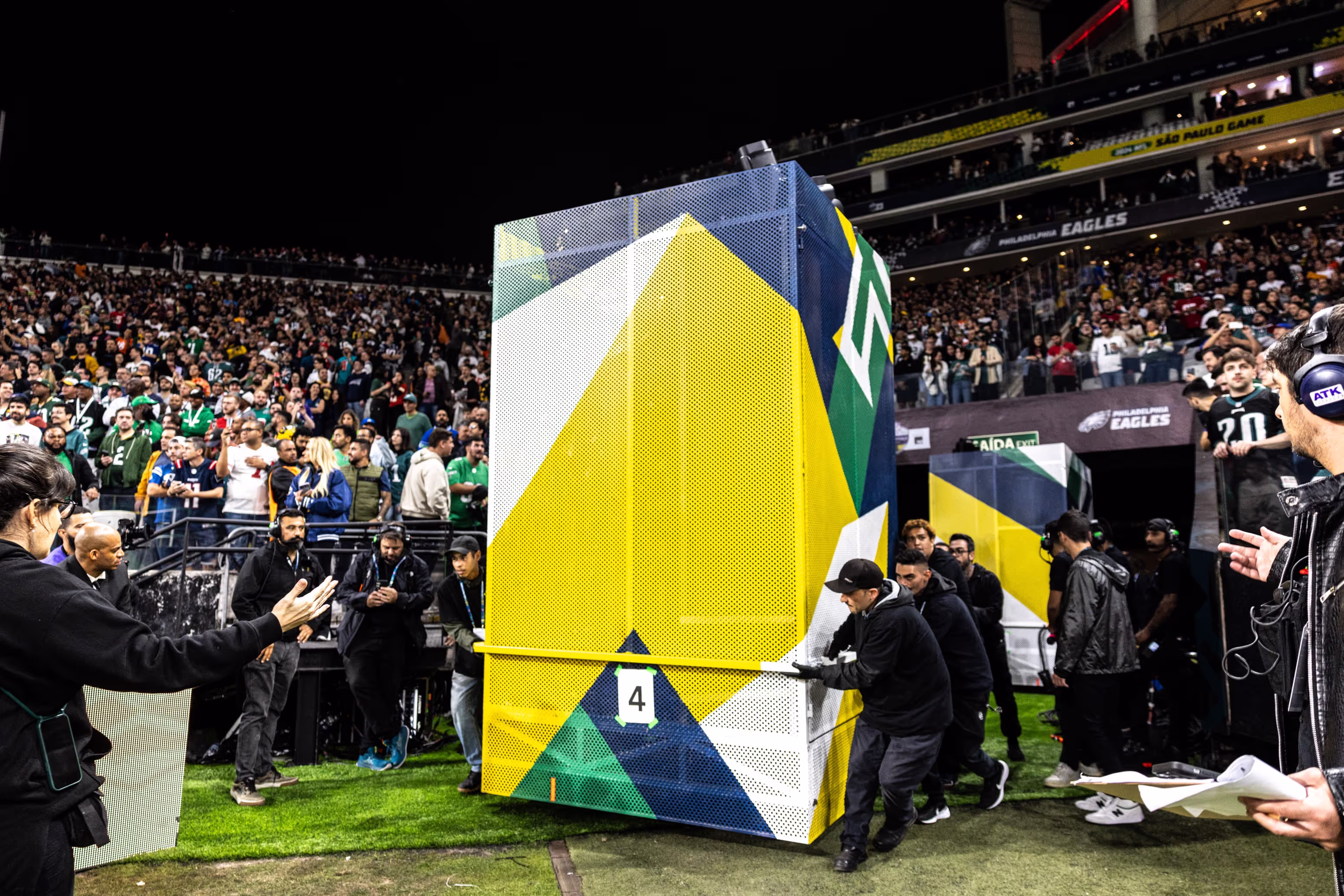 A crowd of people standing around a giant box.
