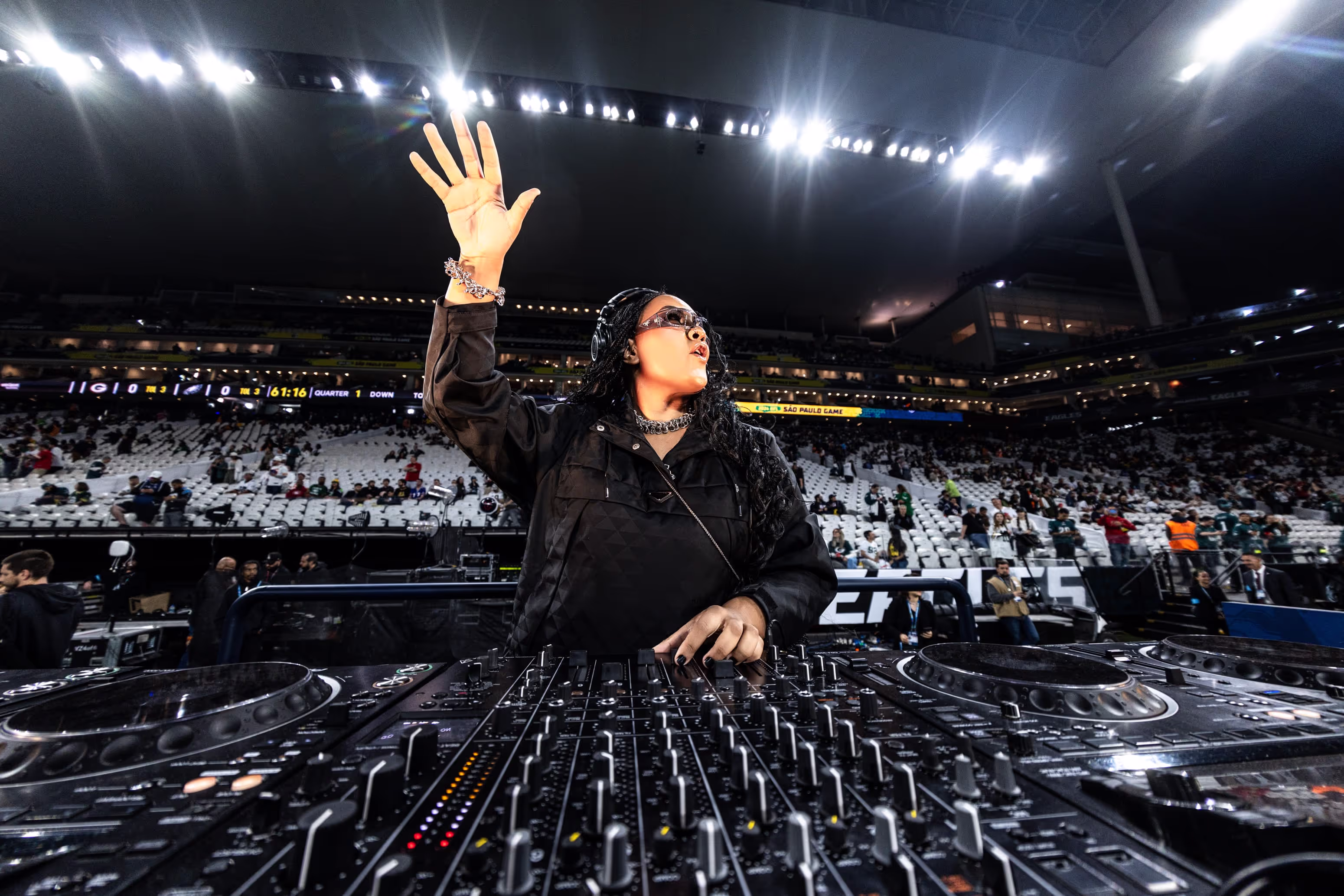 A dj in front of a large crowd at a concert.