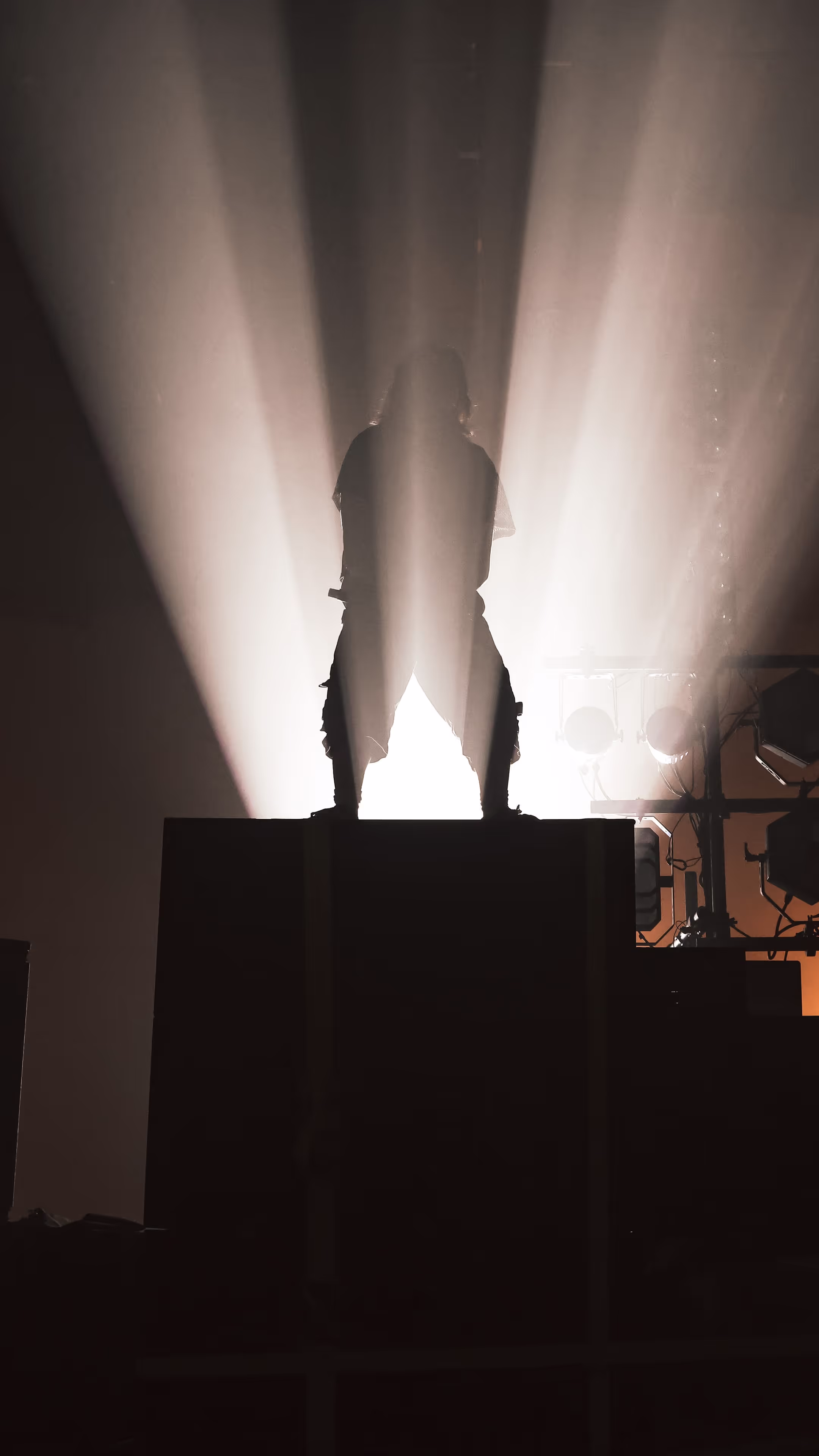 A man standing on top of a stage under a spotlight.